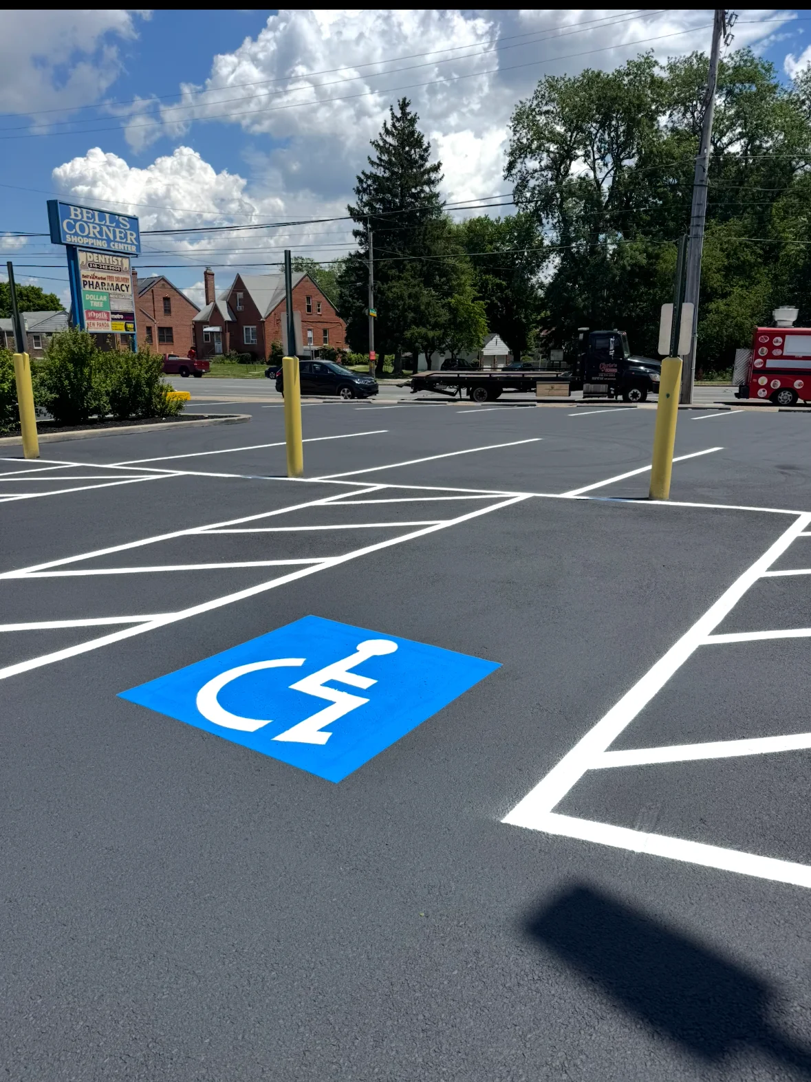 Newly striped asphalt parking lot with white lines and blue ADA wheelchair symbol