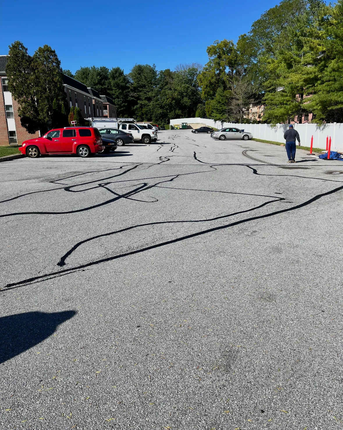 Parking lot with dark crack fill lines applied across asphalt surface